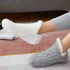 Grå stickade toffelsockor som visar det mjuka fodret