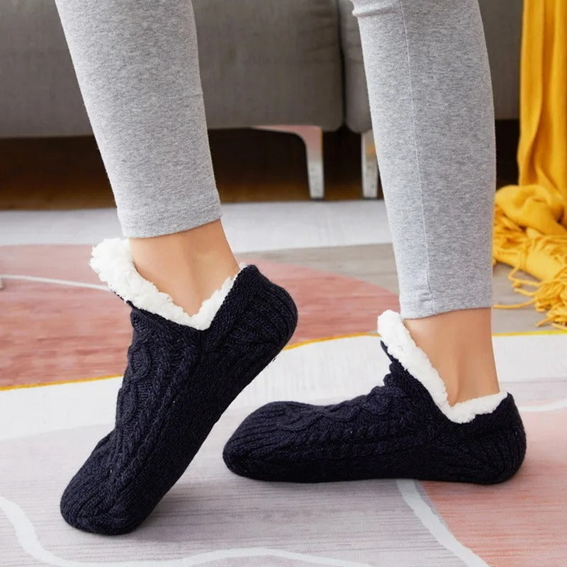 Marinblå stickade toffelsockor burna inomhus